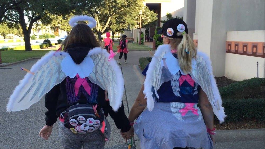 Kim and her mom, Jennifer, at the 3-Day holding hands wearing angel wings.